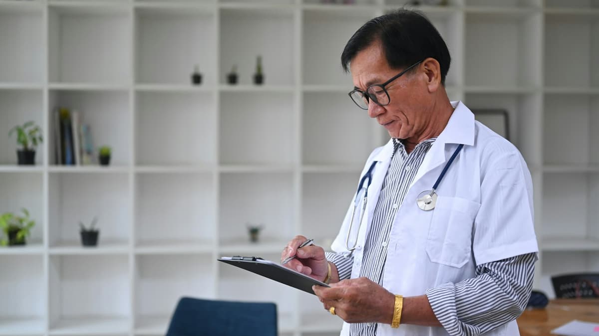 Médico experiente segurando uma prancheta